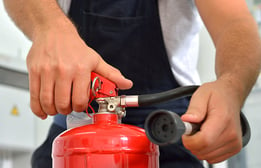 man using fire extinguisher