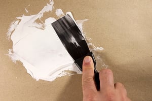 person spackling preparting for painting