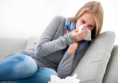 sneezing woman on couch