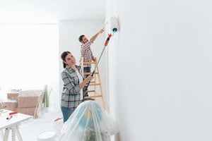 couple painting interior of home