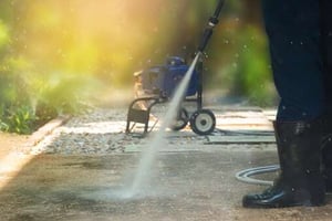 person power washing driveway