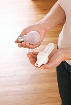 woman_holding_regular_lightbulb_and_energy_saving_lightbulb