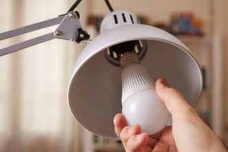 hand changing a light bulb