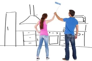 couple painting kitchen during renovation