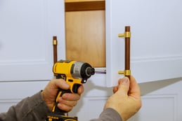 kitchen cabinet hardware being installed