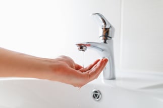 hand under faucet with low water pressure
