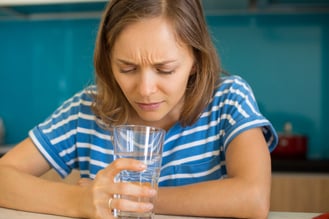 woman looking at glass of water