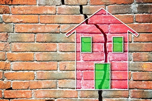 cracked_brick_wall_with_colored_house_drawn_on_it